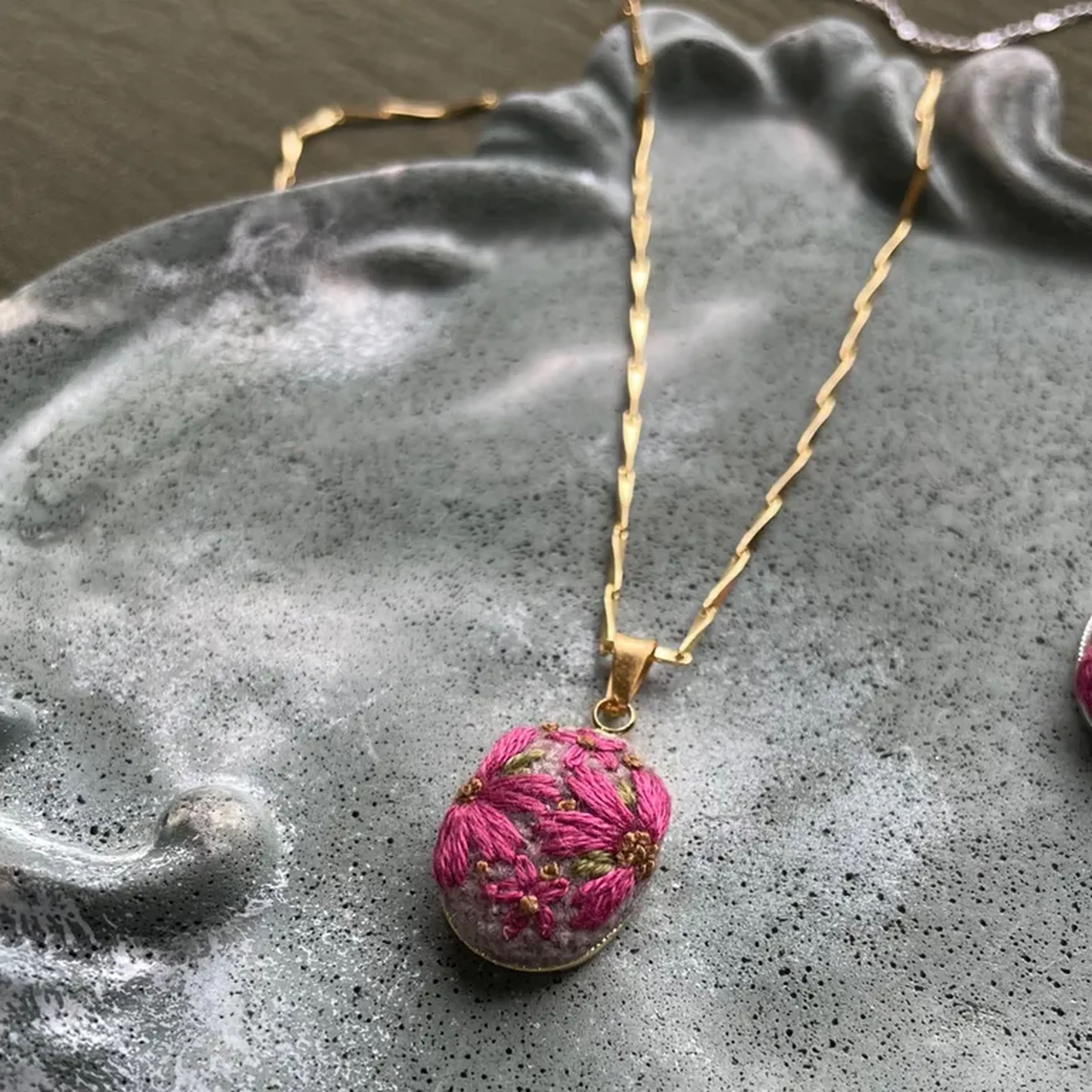 Colar dourado com bordado de flor rosa imagem