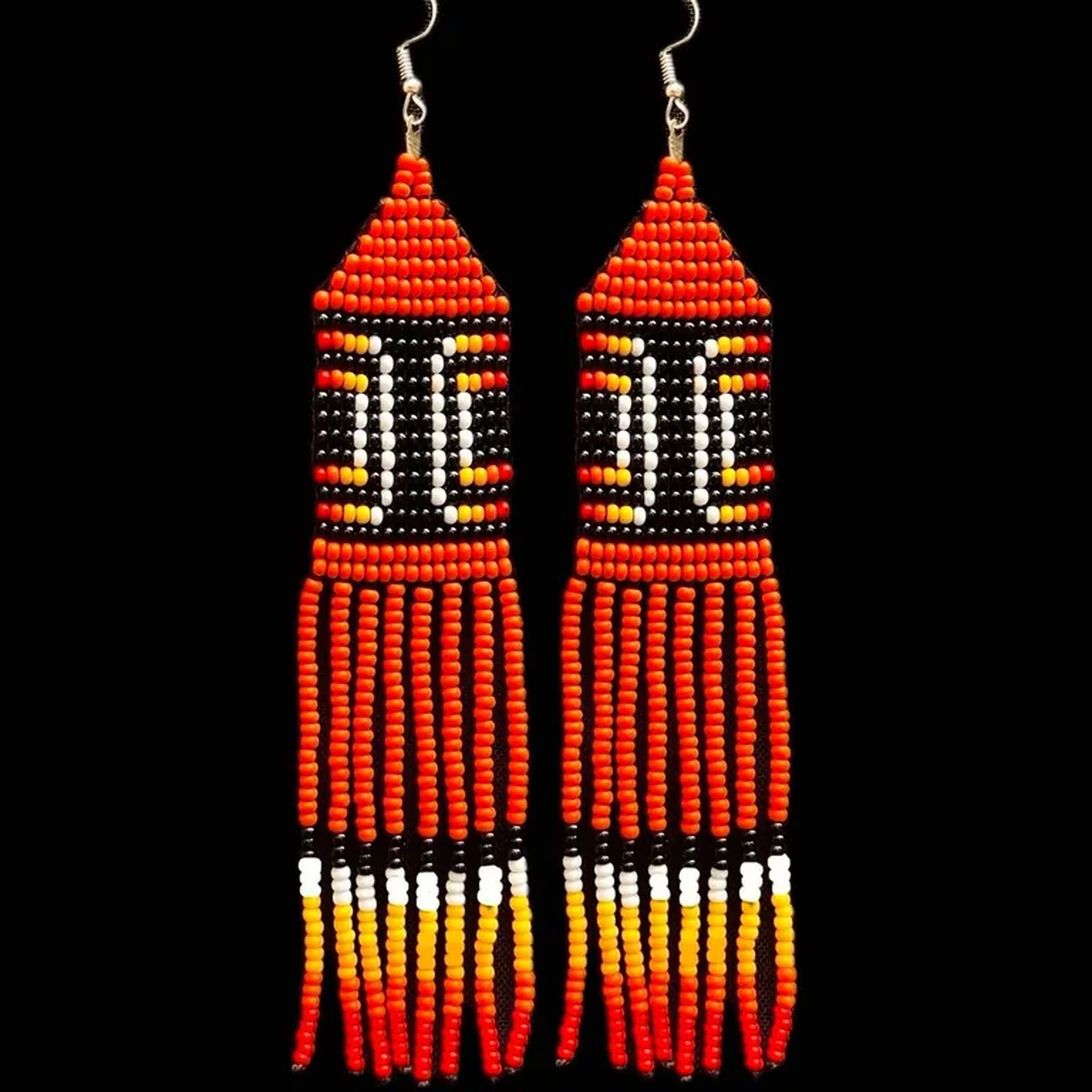 brinco com grafismo do Kuarup fundo laranja imagem